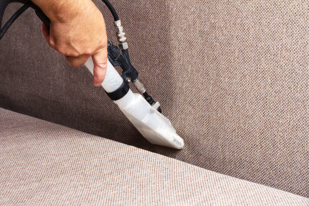 Person cleaning sofa